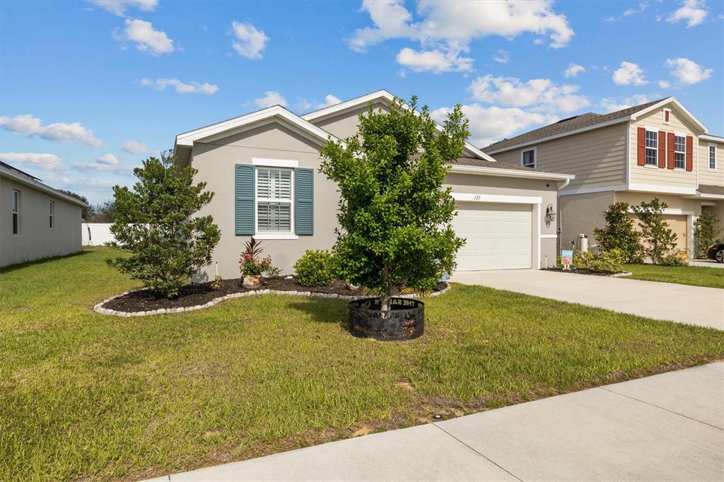 A single-story house with a gray exterior, blue shutters, and a front-facing garage — 125 CRESTVIEW LANE, DUNDEE, FL