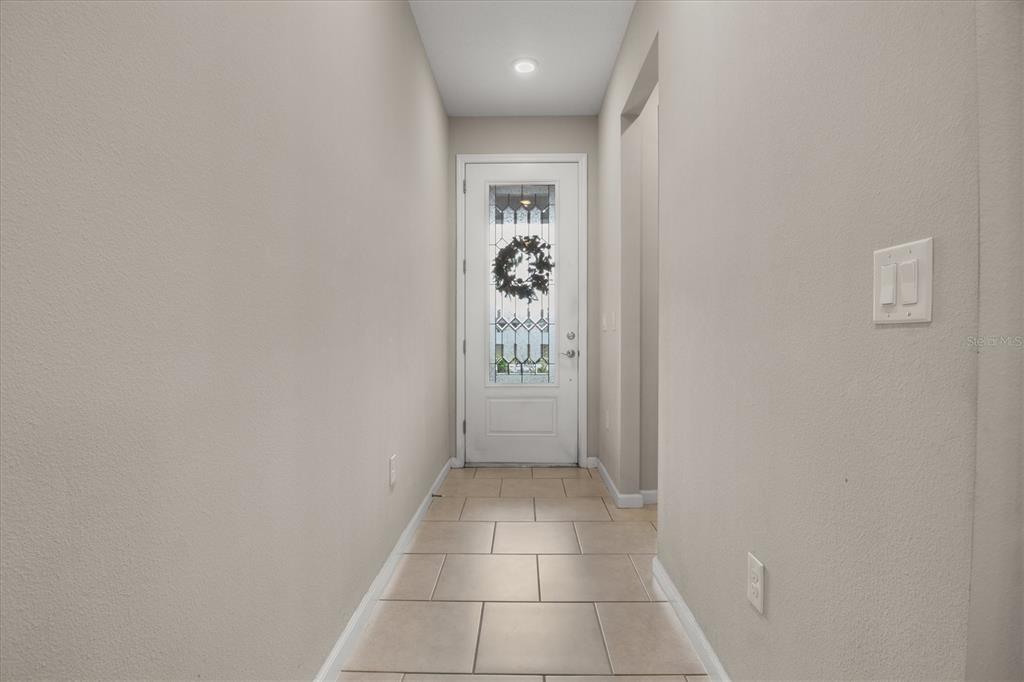 A tiled entryway features a white front door with a decorative glass insert and wreath — 125 CRESTVIEW LANE, DUNDEE, FL