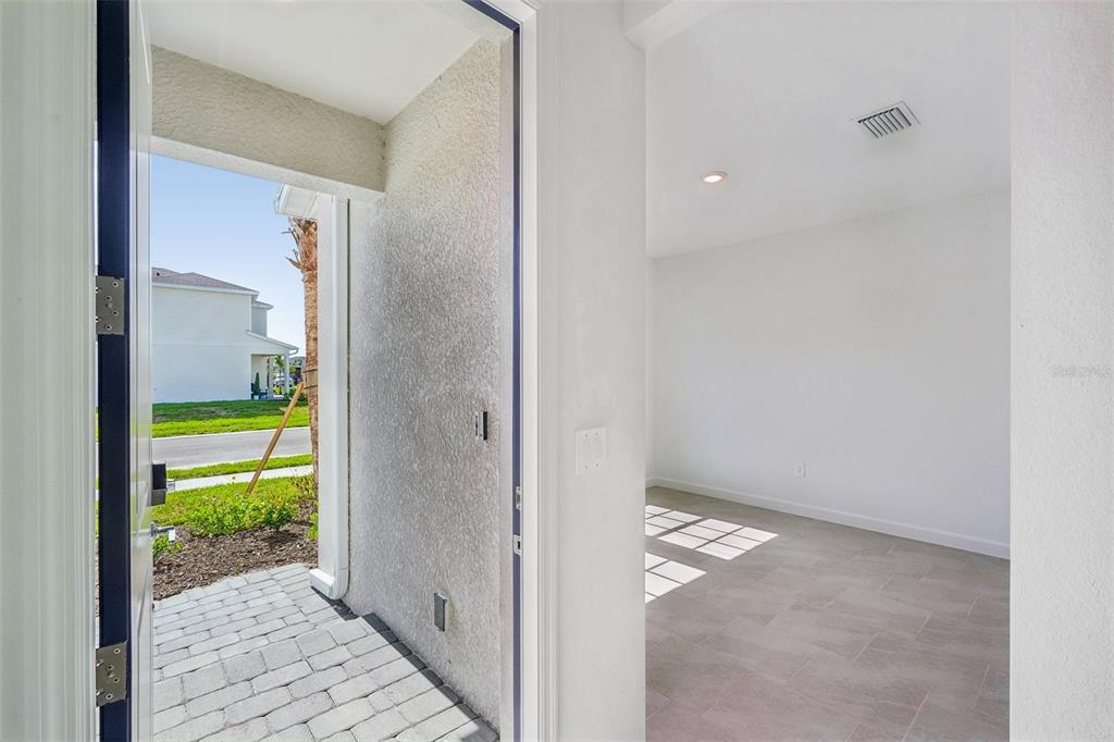 An open doorway reveals a tiled interior room and a paved exterior entryway — 13296 GRASSMERE COURT, PUNTA GORDA, FL