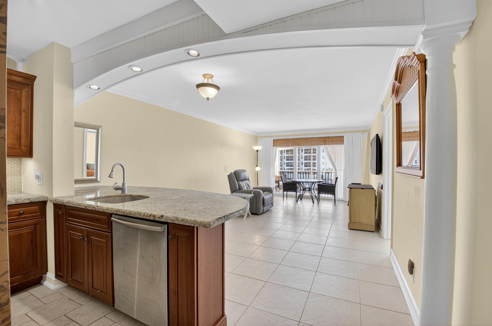 A kitchen with granite countertops and stainless steel appliances opens into a tiled living area — 2871 N Ocean Boulevard # V247, Boca Raton FL 33431, BOCA RATON, FL
