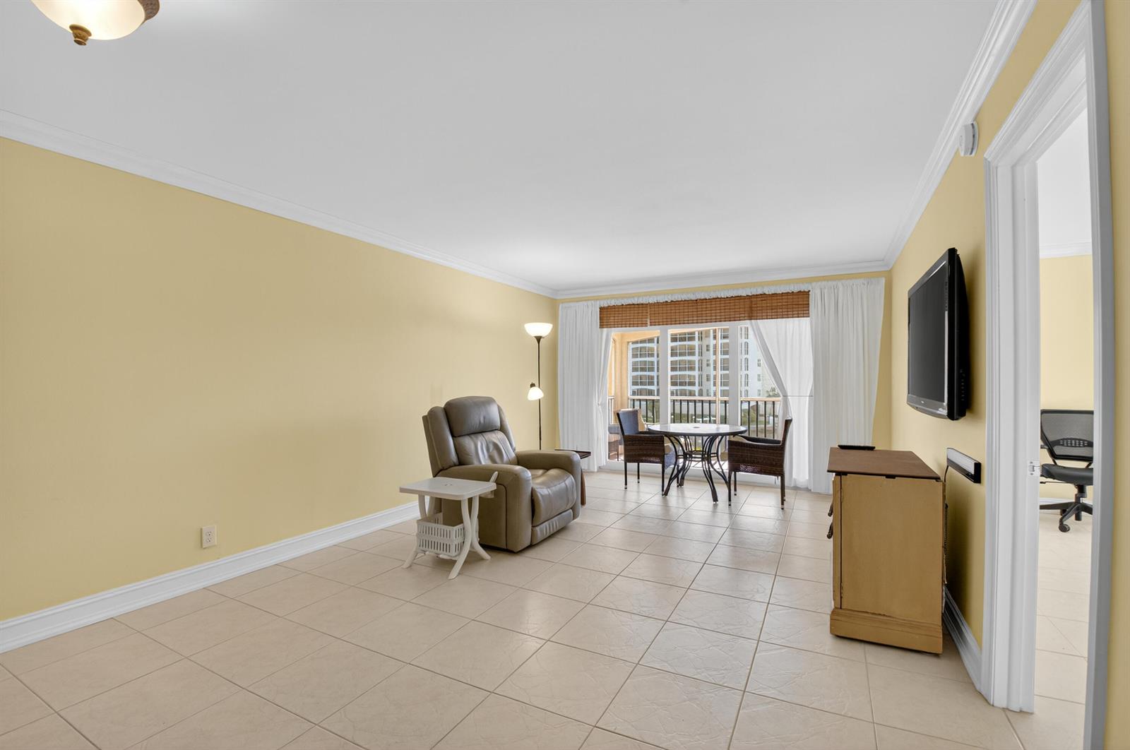 A living room with light yellow walls, tile flooring, a recliner, and a dining set — 2871 N Ocean Boulevard # V247, Boca Raton FL 33431, BOCA RATON, FL
