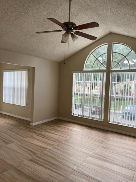 A living room with vaulted ceilings, a ceiling fan, wood-look tile floors, and arched windows — 662 YOUNGSTOWN PARKWAY UNIT 206, ALTAMONTE SPRINGS, FL