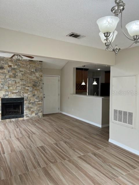 A living room features a stone fireplace, wood-look tile flooring, and an open kitchen pass-through — 662 YOUNGSTOWN PARKWAY UNIT 206, ALTAMONTE SPRINGS, FL