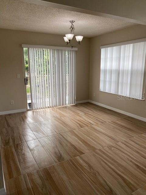 A dining area features wood-look tile flooring, a chandelier, and vertical blinds on sliding doors — 662 YOUNGSTOWN PARKWAY UNIT 206, ALTAMONTE SPRINGS, FL