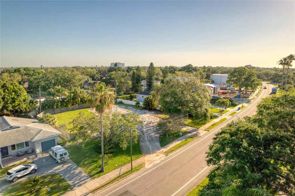 An aerial view shows a vacant lot situated between two houses along a paved road — 1020 SNELL ISLE BOULEVARD NE, ST PETERSBURG, FL