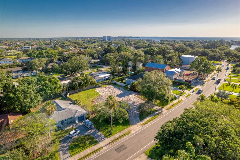 An aerial view shows a vacant residential lot situated between two houses along a road — 1020 SNELL ISLE BOULEVARD NE, ST PETERSBURG, FL