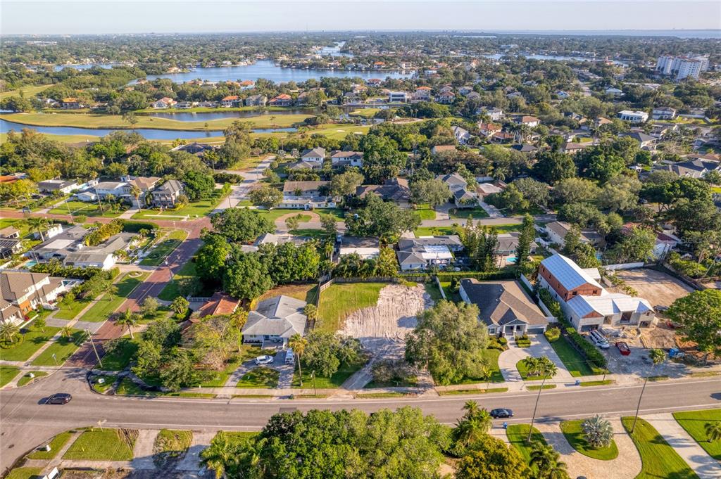 An aerial view shows a residential neighborhood with a vacant lot between two houses — 1020 SNELL ISLE BOULEVARD NE, ST PETERSBURG, FL