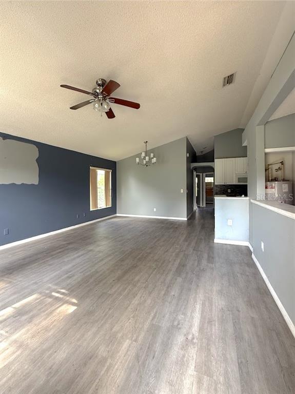 An open-concept living and dining area features gray walls, wood-look flooring, and a ceiling fan — 6313 LIVEWOOD OAKS DRIVE, ORLANDO, FL