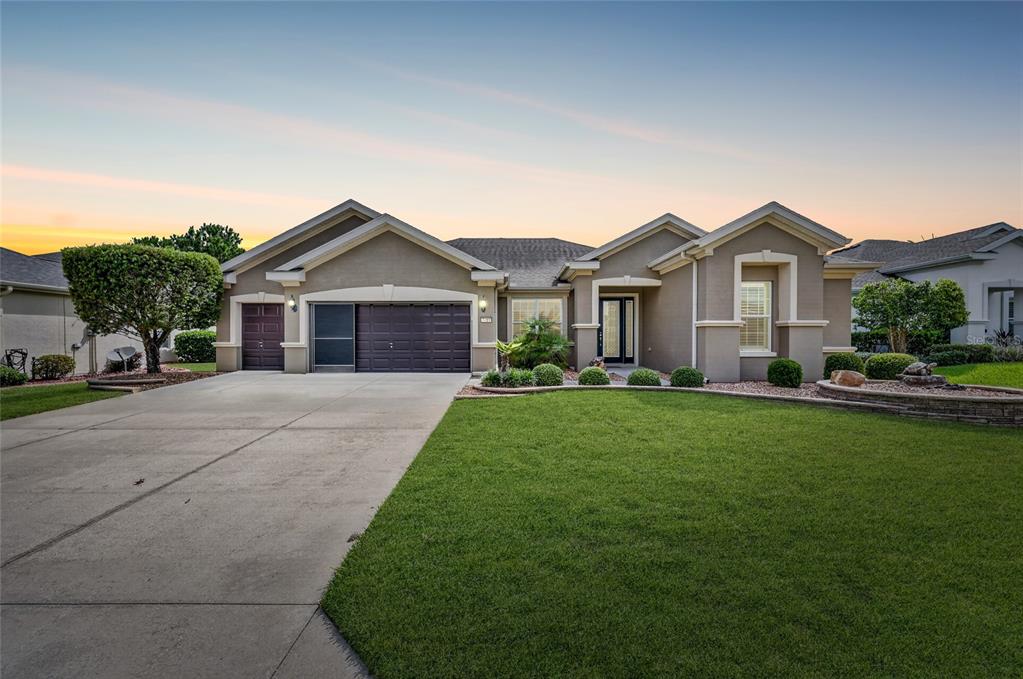 A single-story suburban house with a three-car garage and a manicured front lawn — 7419 SW 97TH TERRACE ROAD, OCALA, FL