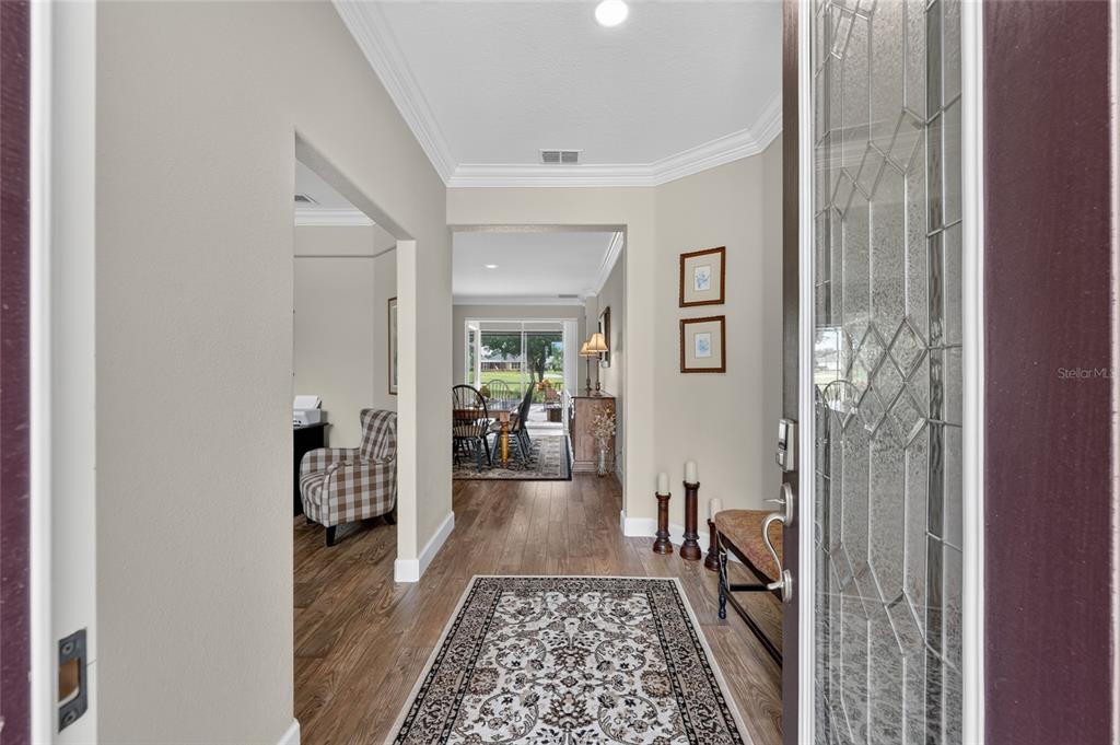 A view from an entryway into a home with wood-look flooring and a dining area — 7419 SW 97TH TERRACE ROAD, OCALA, FL