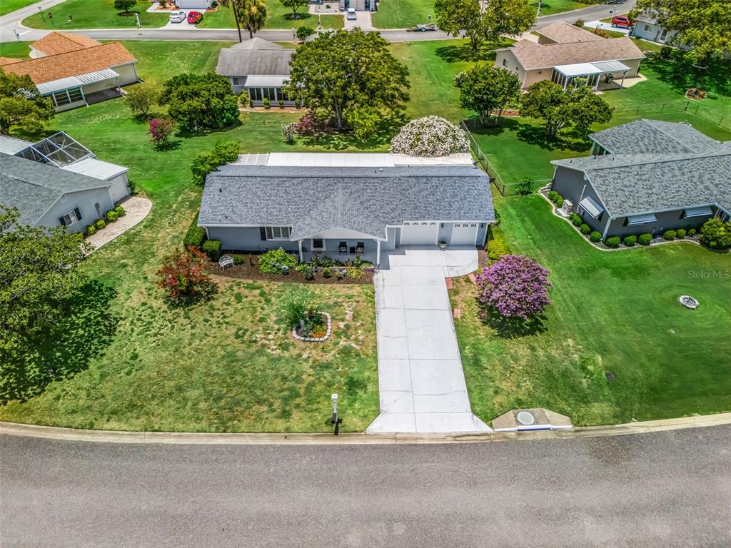 An aerial view shows a single-story house with a gray roof and a concrete driveway — 17584 SE 105TH TERRACE, SUMMERFIELD, FL