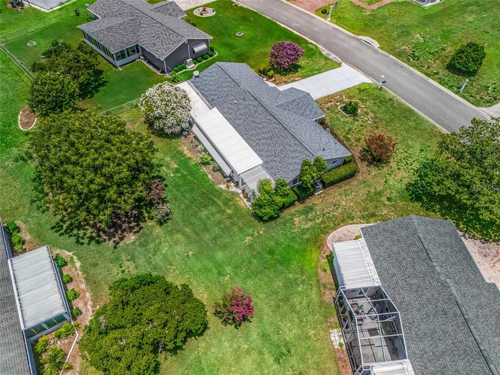 An aerial view shows several houses with gray roofs and screened-in patios surrounded by lawns — 17584 SE 105TH TERRACE, SUMMERFIELD, FL