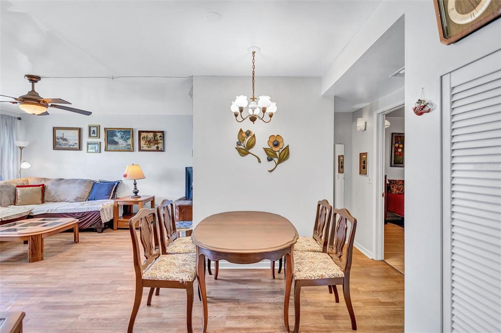 A dining area with a wooden table and chairs sits adjacent to a living room — 5940 21ST STREET N UNIT 11, ST PETERSBURG, FL
