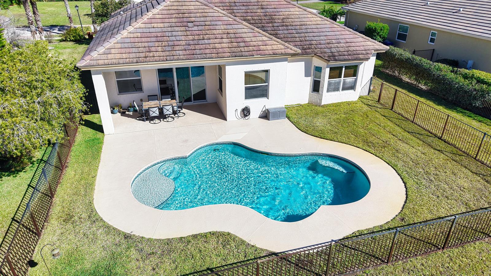 An aerial view of a house backyard featuring a swimming pool and a covered patio — 7621 Fieldstone Ranch Square, Vero Beach FL 32967, VERO BEACH, FL
