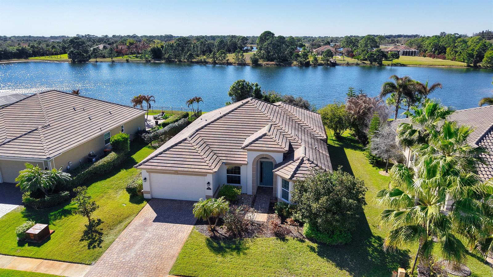 An aerial view shows a single-story house with a tiled roof and a paved driveway — 7621 Fieldstone Ranch Square, Vero Beach FL 32967, VERO BEACH, FL