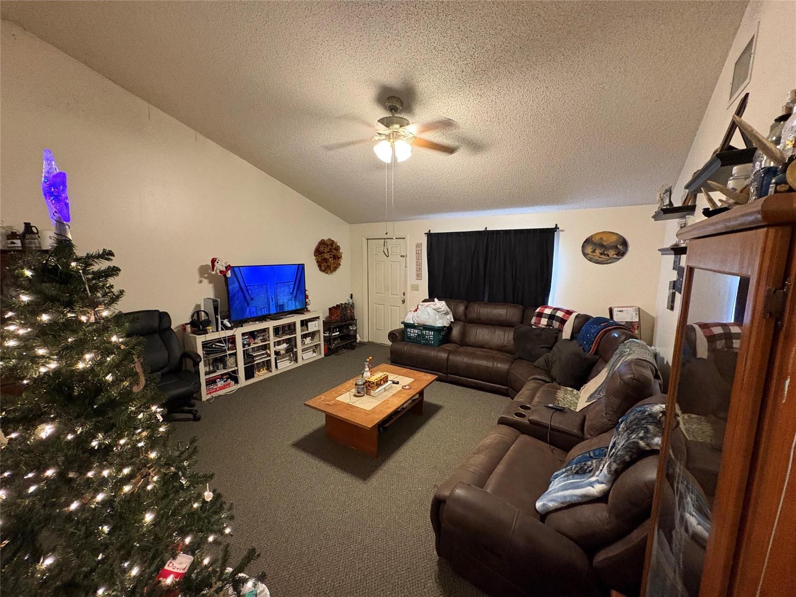 A living room features a vaulted ceiling, a large brown sectional, and a Christmas tree — 540 NW 24th Avenue, Okeechobee FL 34972, OKEECHOBEE, FL