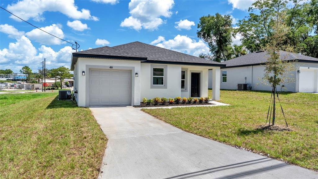 A single-story house with a white exterior, a gray roof, and a concrete driveway — 46 ASH STREET, HAINES CITY, FL