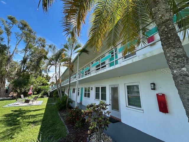 A two-story apartment building exterior with palm trees and a grassy lawn area — 6100 21ST STREET N UNIT 15, ST PETERSBURG, FL