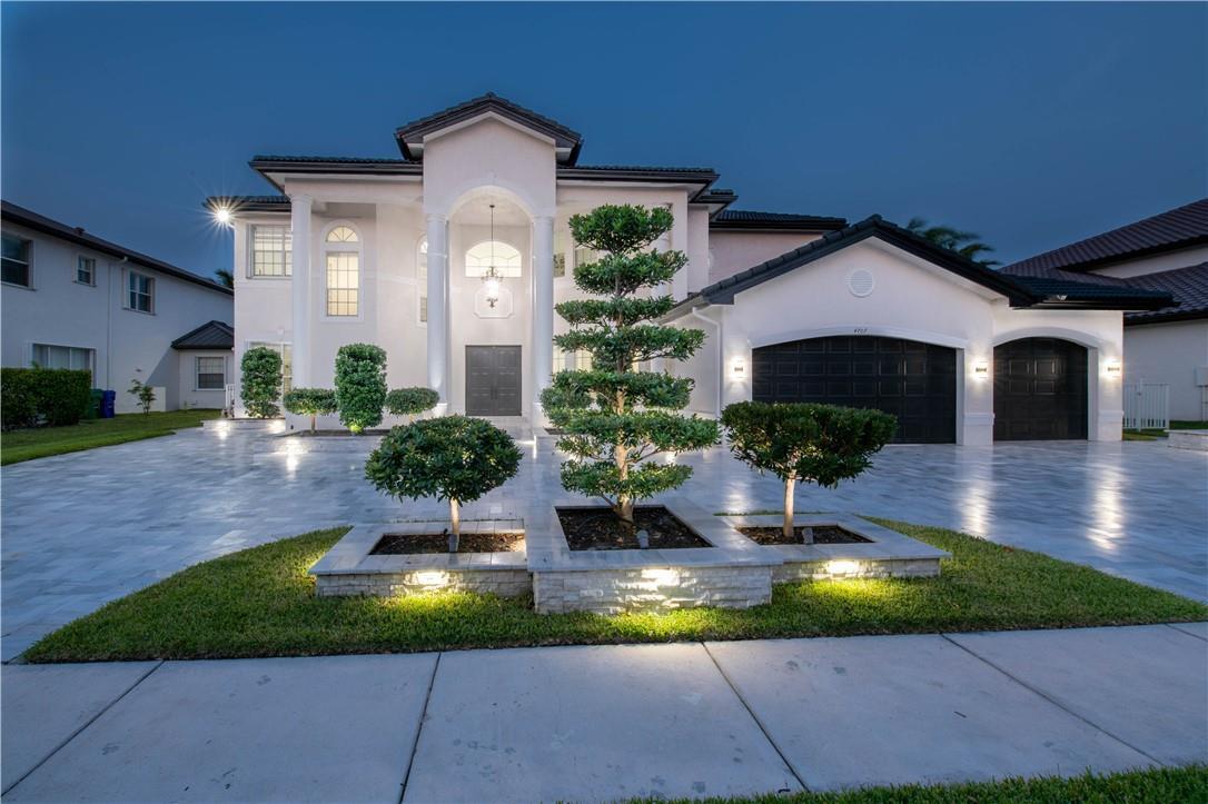 A two-story white house with a paved driveway, manicured landscaping, and a three-car garage — 4707 SW 195th Terrace, Miramar FL 33029, MIRAMAR, FL