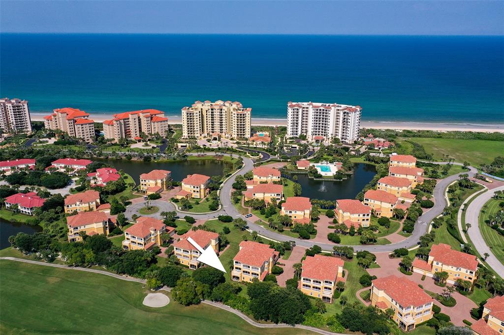 An aerial view of a coastal residential community with multi-story buildings, ponds, and golf course — 120 AVENUE DE LA MER UNIT 1501, PALM COAST, FL
