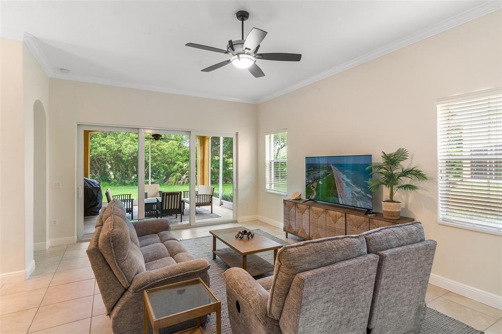 A living room features two gray sofas, a wooden coffee table, and a sliding glass door — 120 AVENUE DE LA MER UNIT 1501, PALM COAST, FL