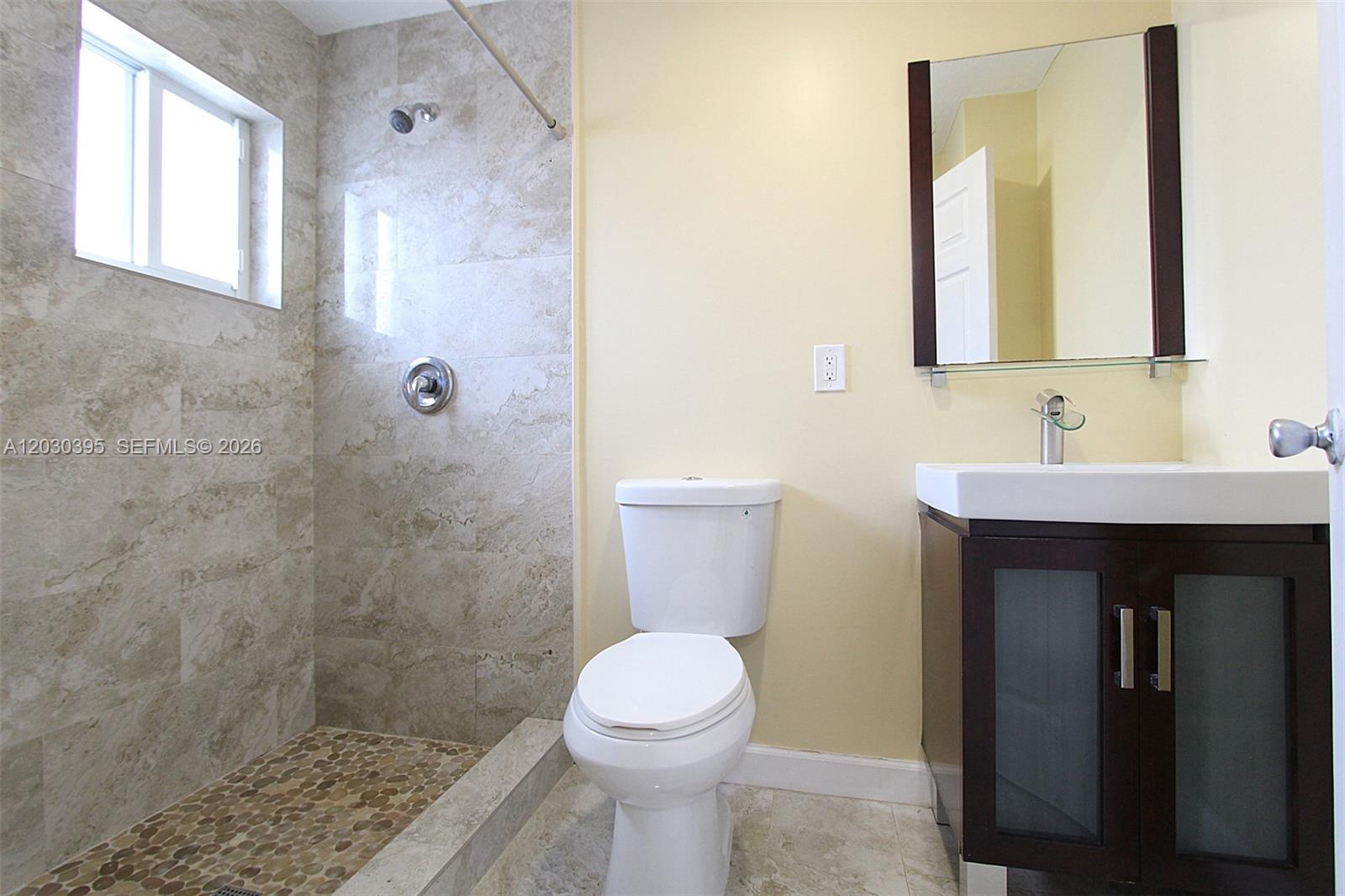 A bathroom features a tiled walk-in shower, a white toilet, and a dark wood vanity — 7281 SW 9th St # 2, Miami FL 33144, MIAMI, FL