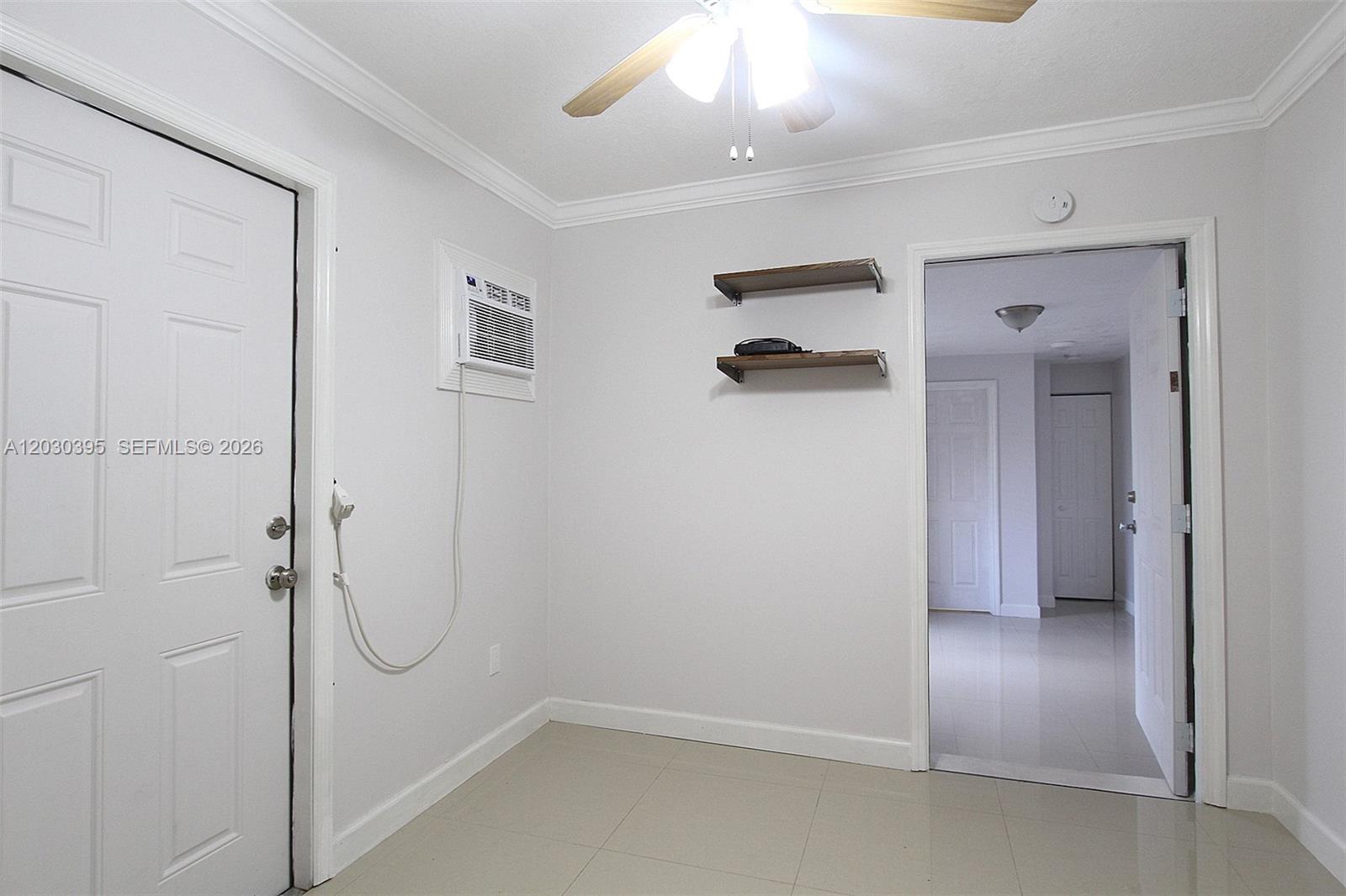 A room with white walls, tile flooring, a ceiling fan, and two wall-mounted shelves — 7281 SW 9th St # 2, Miami FL 33144, MIAMI, FL