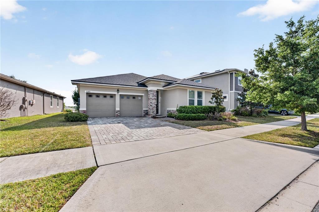 A single-story house with a two-car garage, stone accents, and a paved driveway — 16466 OLIVE HILL DRIVE, WINTER GARDEN, FL