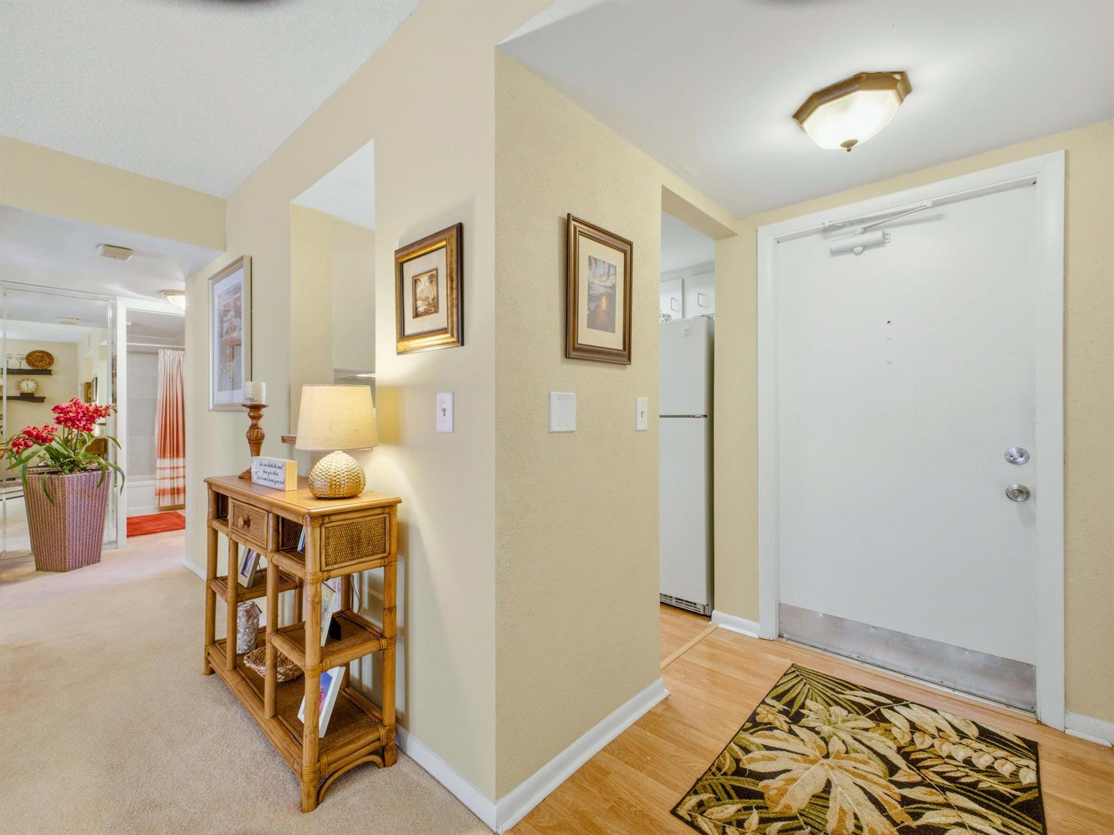 An entryway with a white door, light wood flooring, and a wooden console table — 6625 S Oriole Boulevard # 2040, Delray Beach FL 33446, DELRAY BEACH, FL