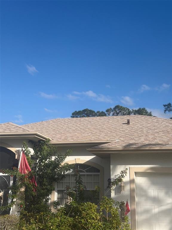 The exterior of a house features a tan shingled roof, stucco walls, and a garage — 3816 N CRANBERRY BOULEVARD, NORTH PORT, FL
