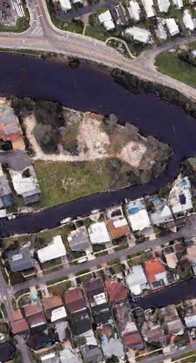 This aerial view shows a vacant, irregularly shaped waterfront lot surrounded by residential houses — 1417 Florian Dr, Dania Beach FL 33004, DANIA BEACH, FL