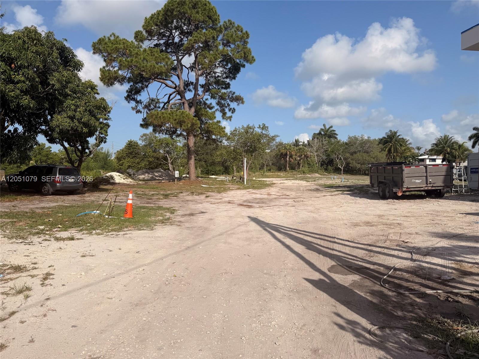 A dirt lot features a large pine tree, a parked SUV, and a utility trailer — 1417 Florian Dr, Dania Beach FL 33004, DANIA BEACH, FL