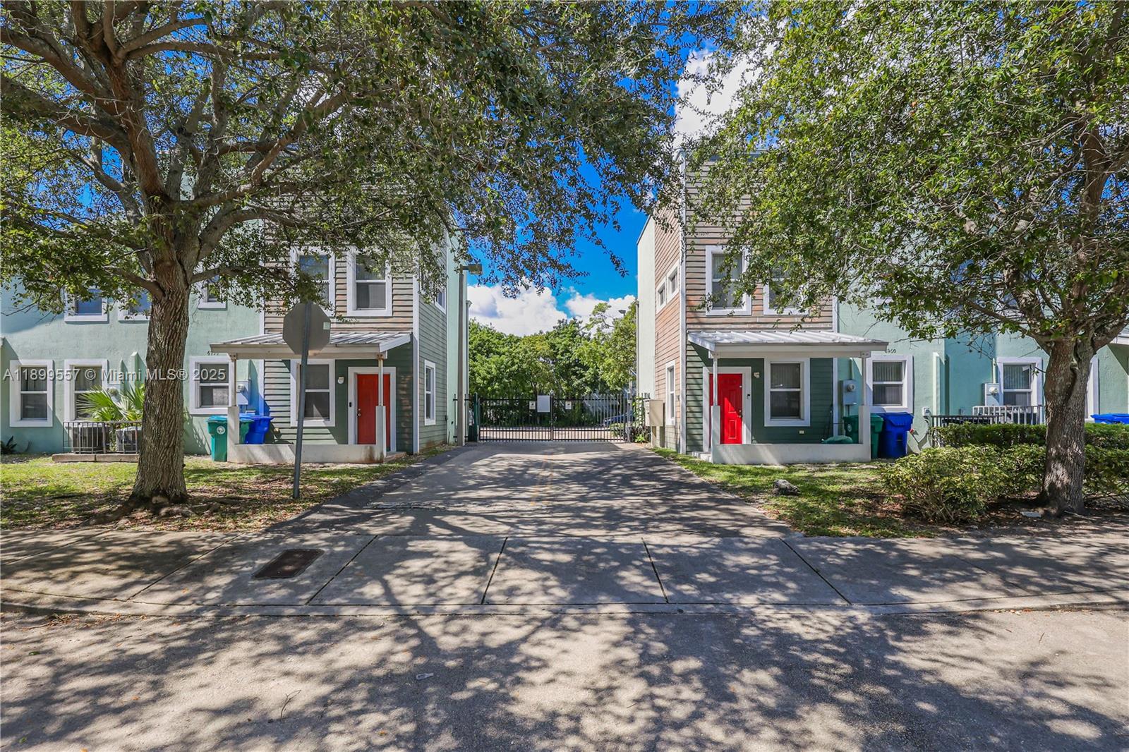 Two identical two-story houses with red front doors face each other across a paved driveway — 6960 NW 4th Ave # 3, Miami FL 33150, MIAMI, FL