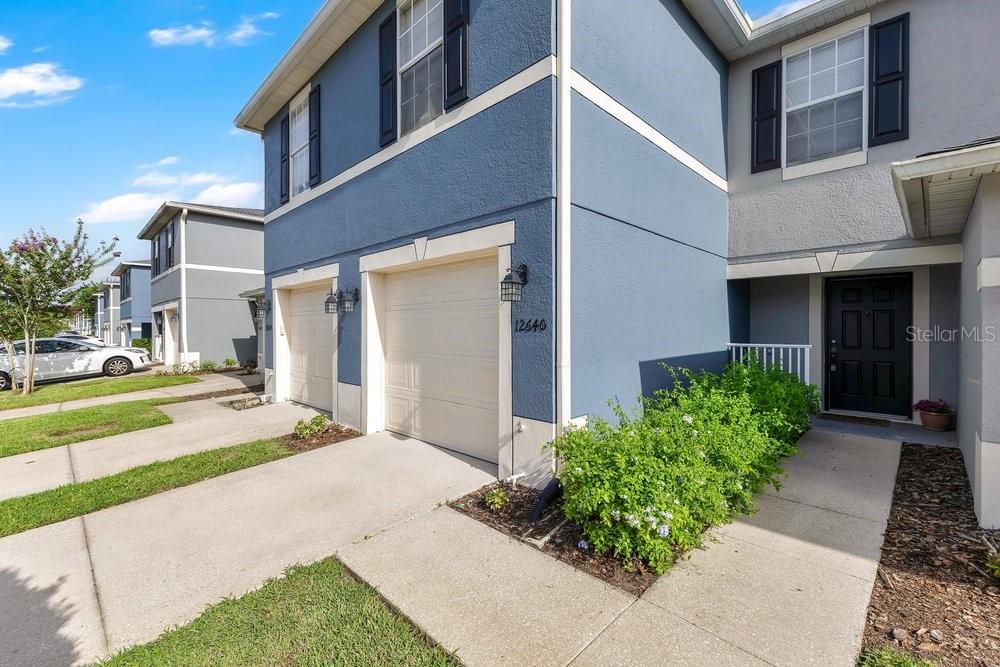 A two-story blue townhouse with a two-car garage and a front entrance walkway — 12640 SOMERSET OAKS STREET, ORLANDO, FL