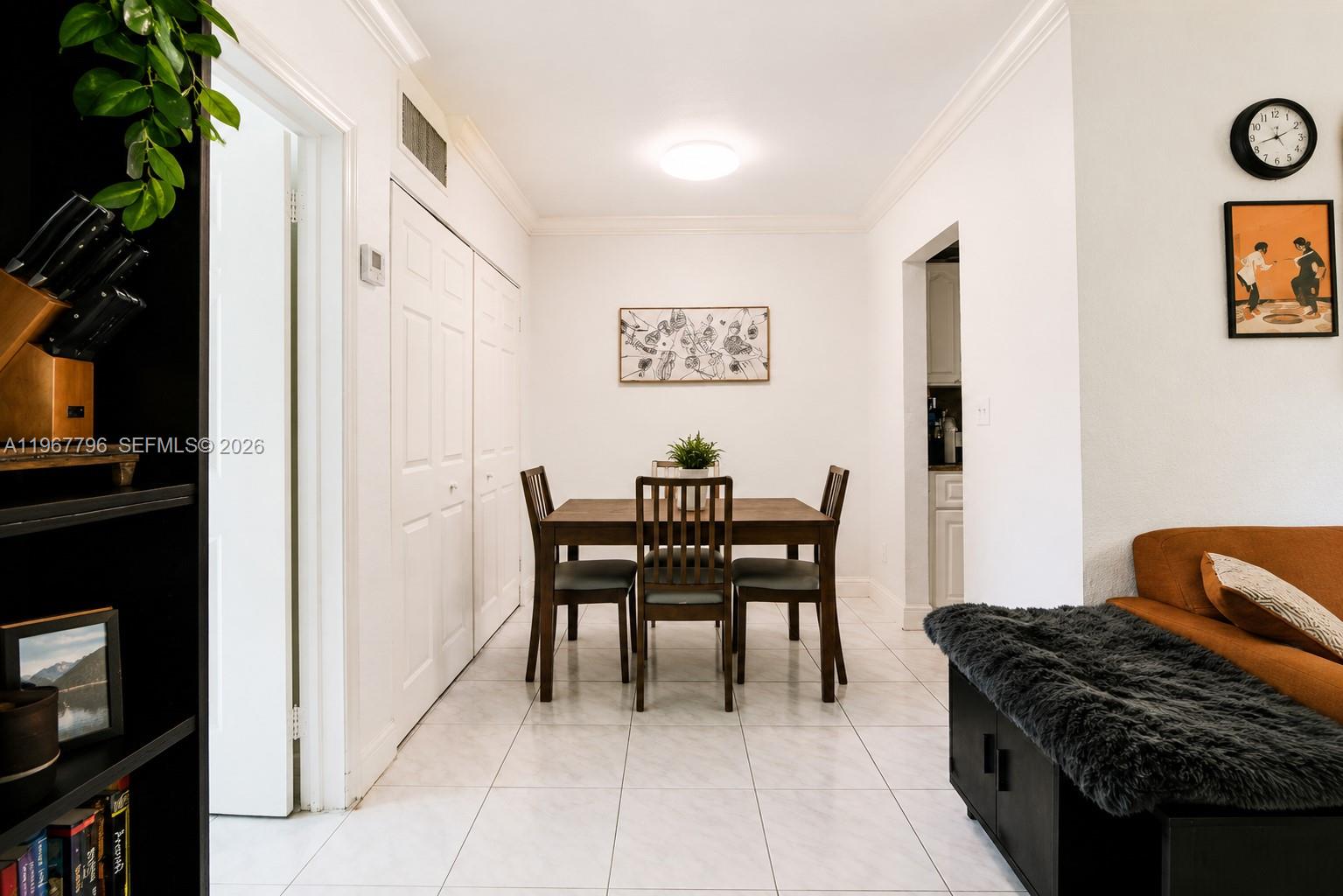 A dining area features a wooden table, four chairs, white tile floors, and white walls — 3901 SW 78th Ct # 116, Miami FL 33155, MIAMI, FL