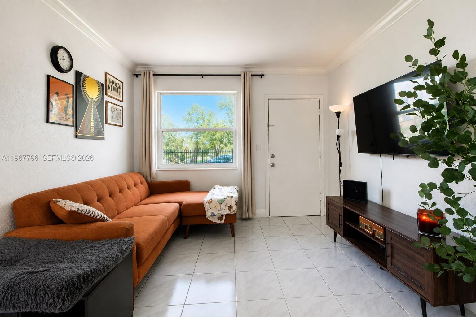A living room features a burnt orange sofa, black bookshelves, and white tiled flooring — 3901 SW 78th Ct # 116, Miami FL 33155, MIAMI, FL