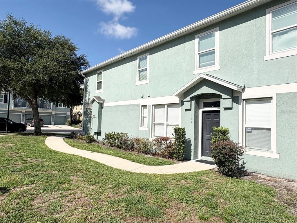 A two-story light green townhouse with a dark front door and a curved concrete walkway — 1931 SAN JACINTO CIRCLE UNIT 1931, SANFORD, FL