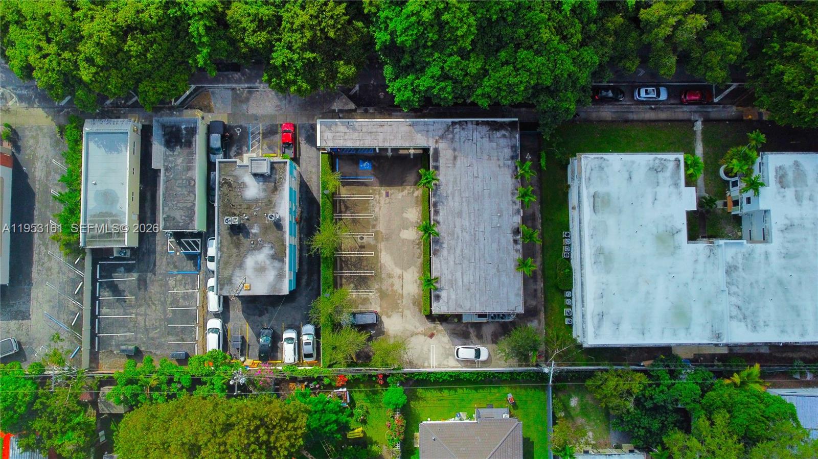An aerial view shows two commercial buildings with parking lots surrounded by trees and greenery — 1875 SW 22nd St, Miami FL 33145, MIAMI, FL