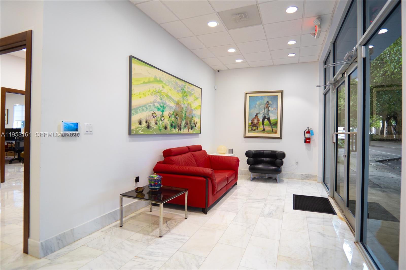 A waiting area features a red sofa, a black armchair, and artwork on white walls — 1875 SW 22nd St, Miami FL 33145, MIAMI, FL