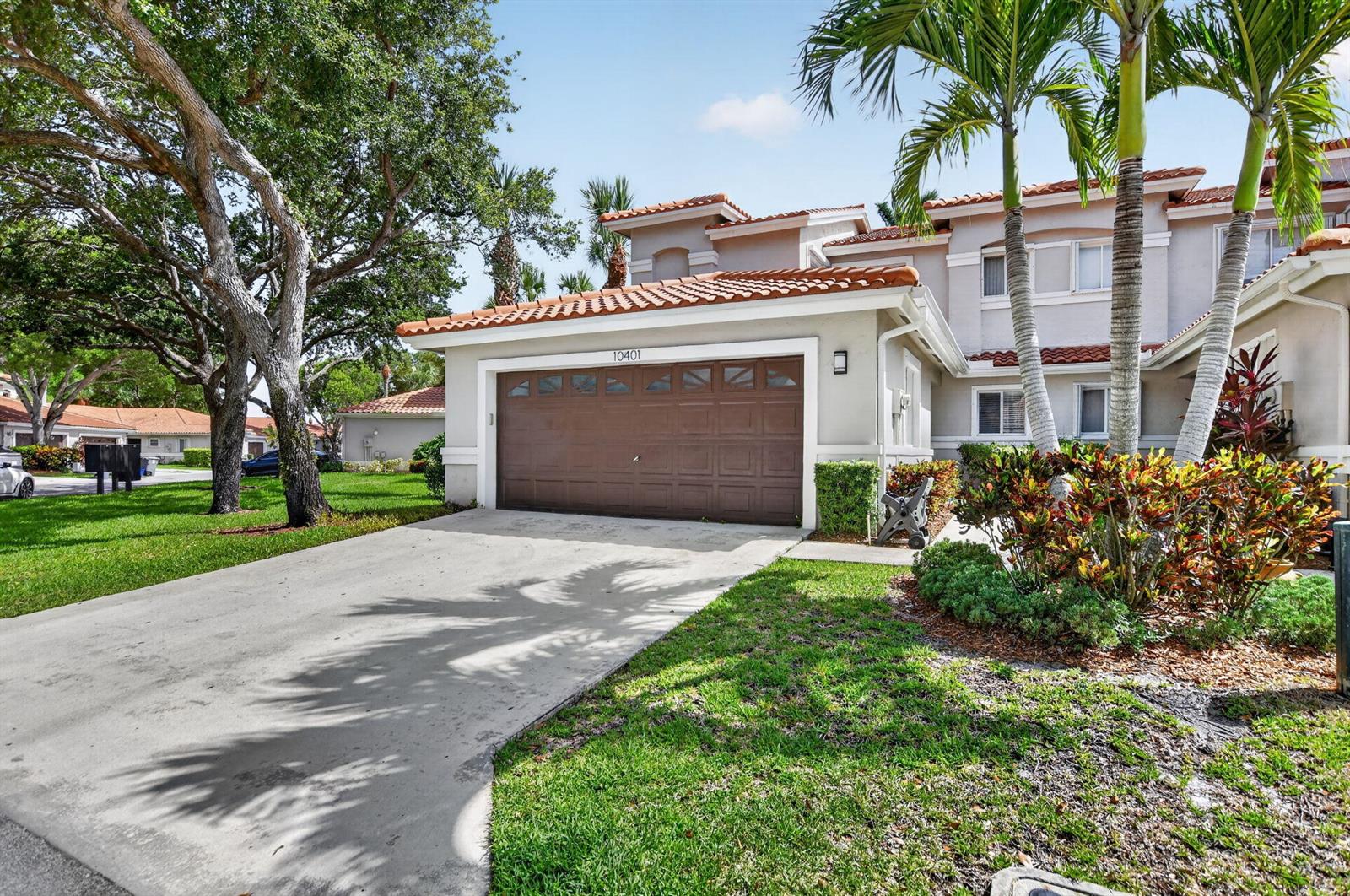 A two-story house with a brown garage door, tile roof, and palm trees in front — 10401 Lake Vista Circle, Boca Raton FL 33498, BOCA RATON, FL