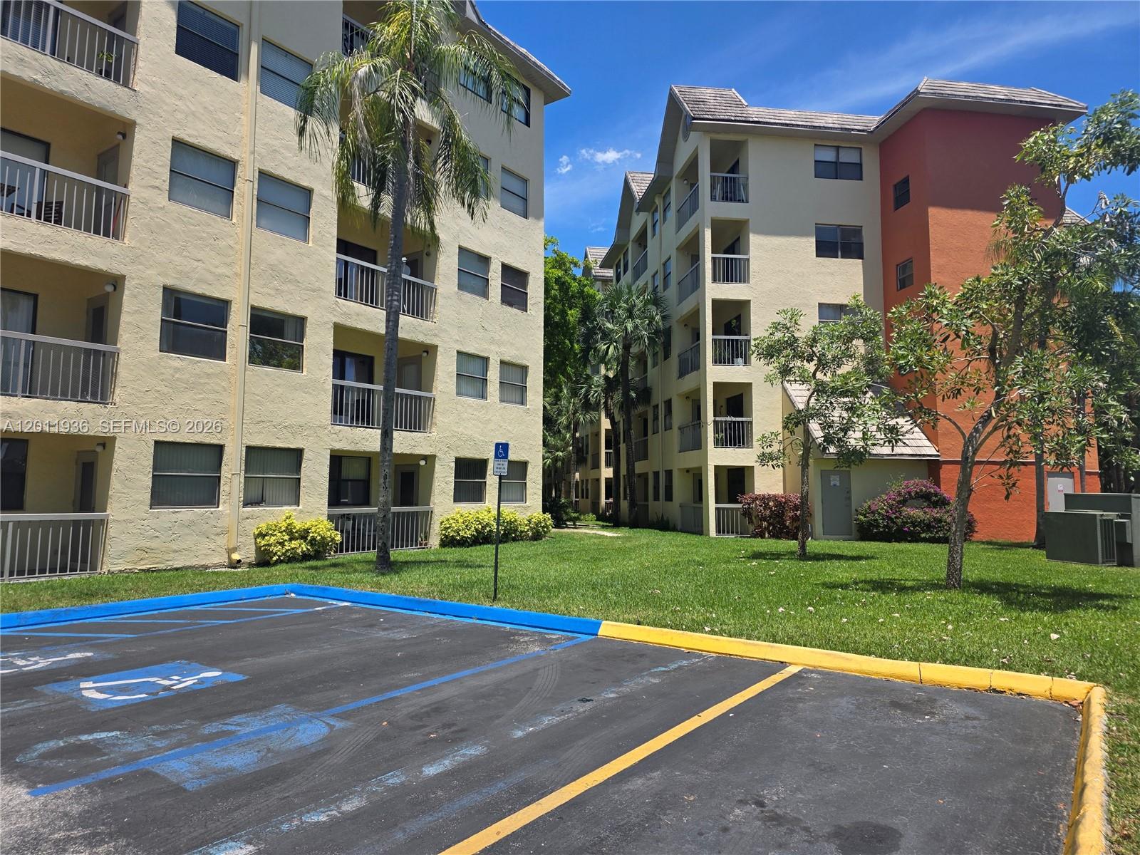 Exterior view of two multi-story apartment buildings with balconies and a handicap-accessible parking space — 8180 Geneva Ct # 322, Doral FL 33166, DORAL, FL