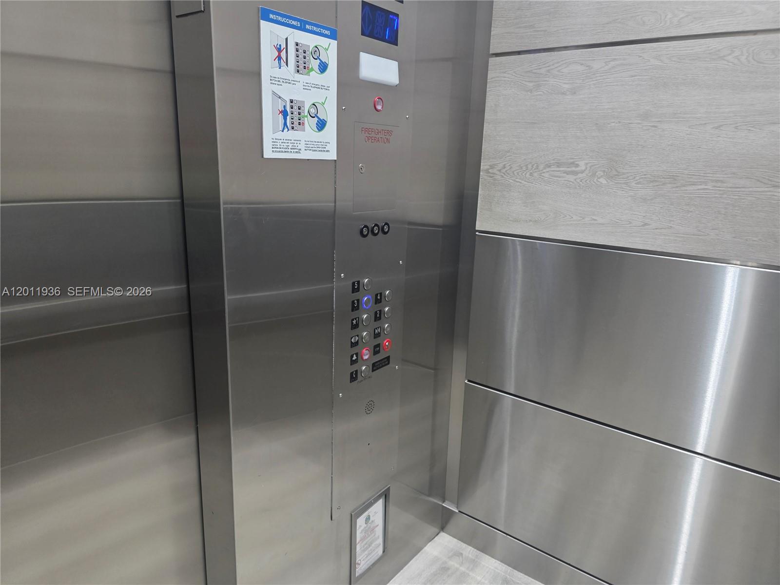 A stainless steel elevator control panel with floor buttons and emergency instructions — 8180 Geneva Ct # 322, Doral FL 33166, DORAL, FL