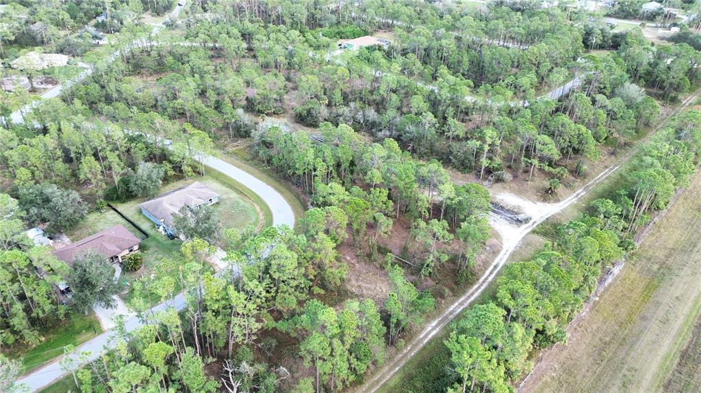 An aerial view shows a wooded residential lot with a paved road and nearby houses — Lots 14 and 15, LATOUR AVENUE, NORTH PORT, FL