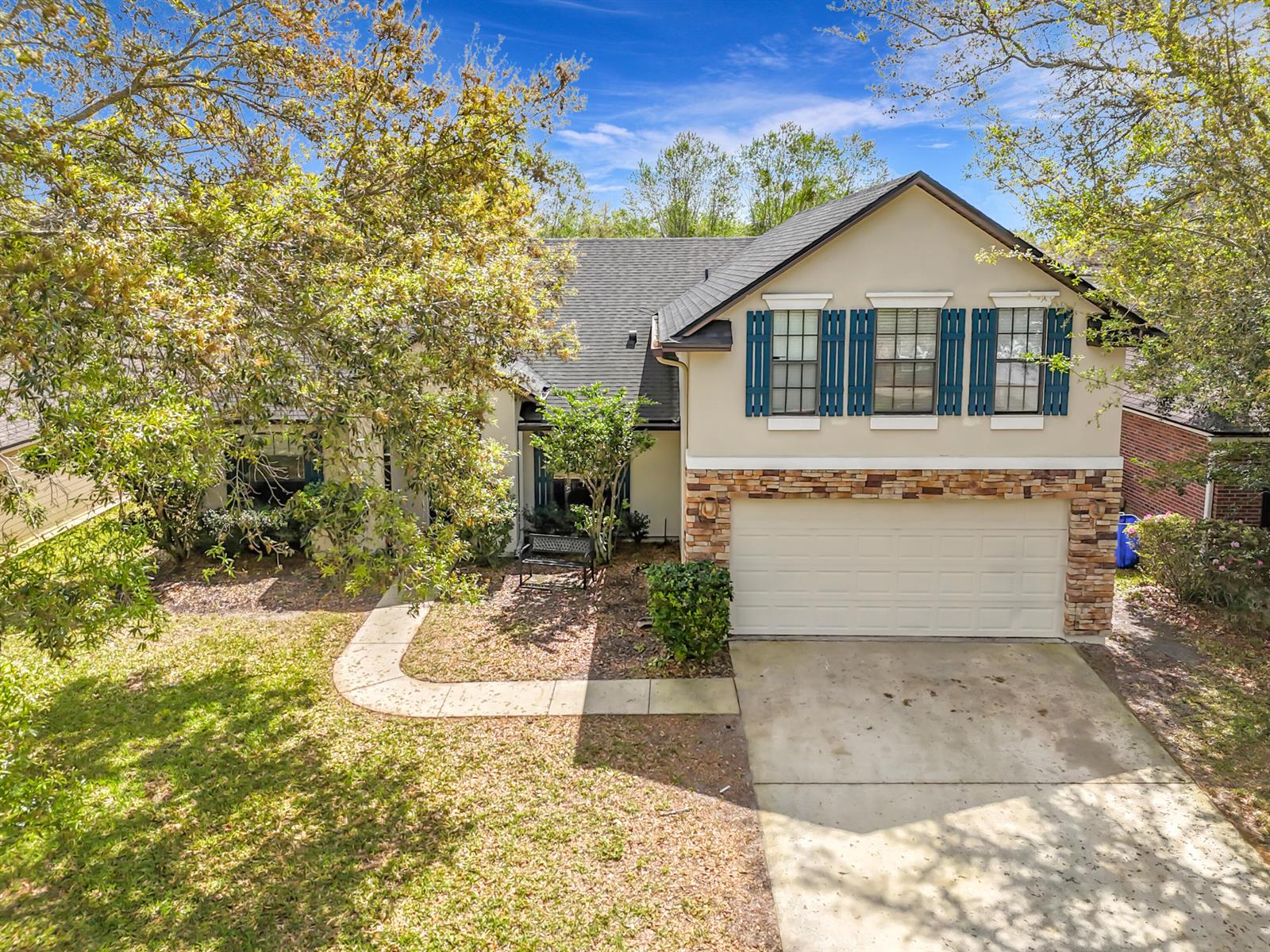 A two-story house with a stone-accented garage, blue shutters, and a concrete walkway — 3371 Classic Oak Court, FL 32065, FL