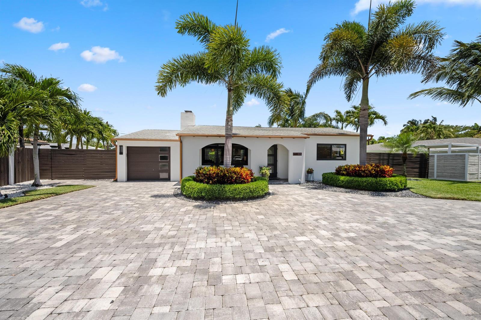 A single-story house with a paved driveway, palm trees, and manicured landscaping in the front — 115 Highland Lane, Delray Beach FL 33444, DELRAY BEACH, FL