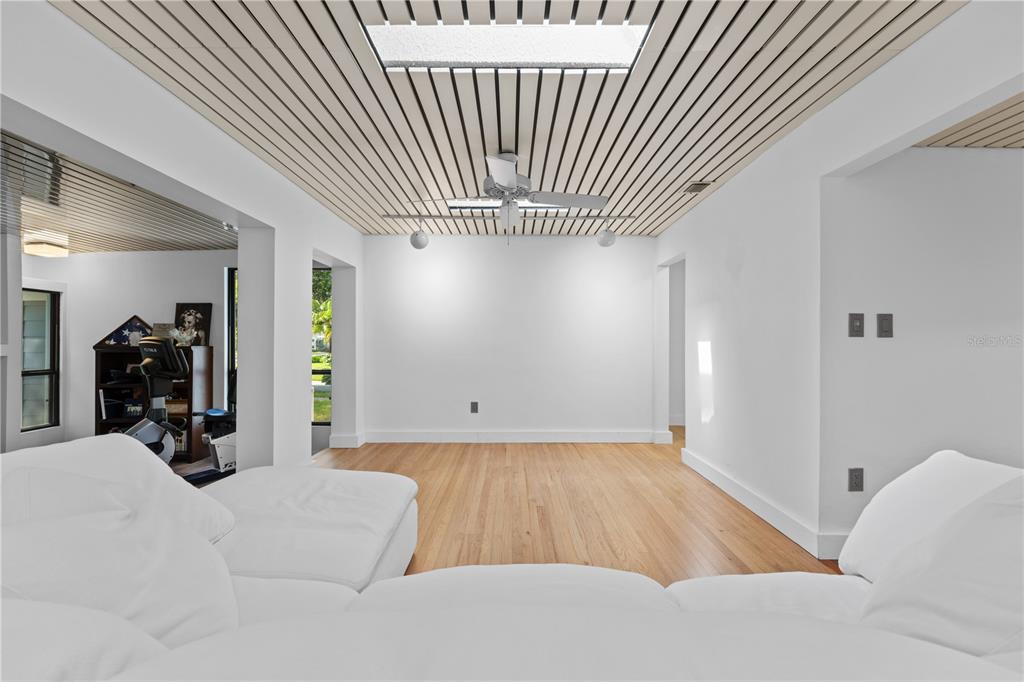 A living room with a slatted wood ceiling, a skylight, and light hardwood flooring — 932 N HYER AVENUE, ORLANDO, FL