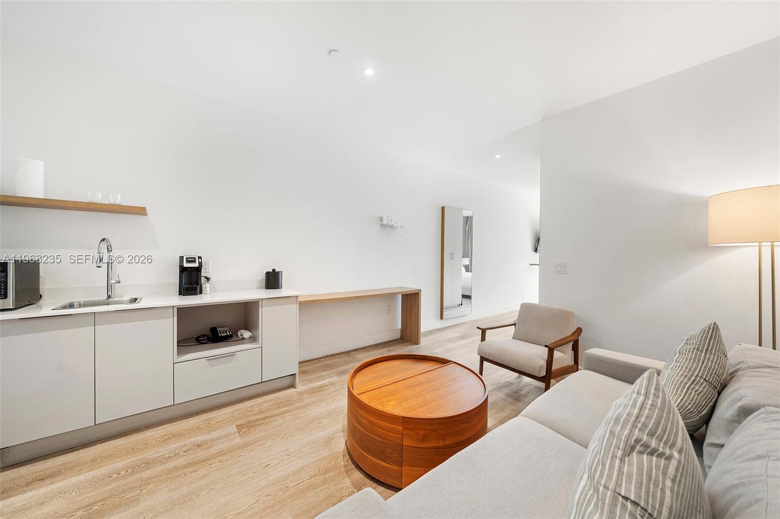 A modern living room features a kitchenette, a wooden coffee table, and a sofa — 229 SW 9th St # 208, Miami FL 33130, MIAMI, FL
