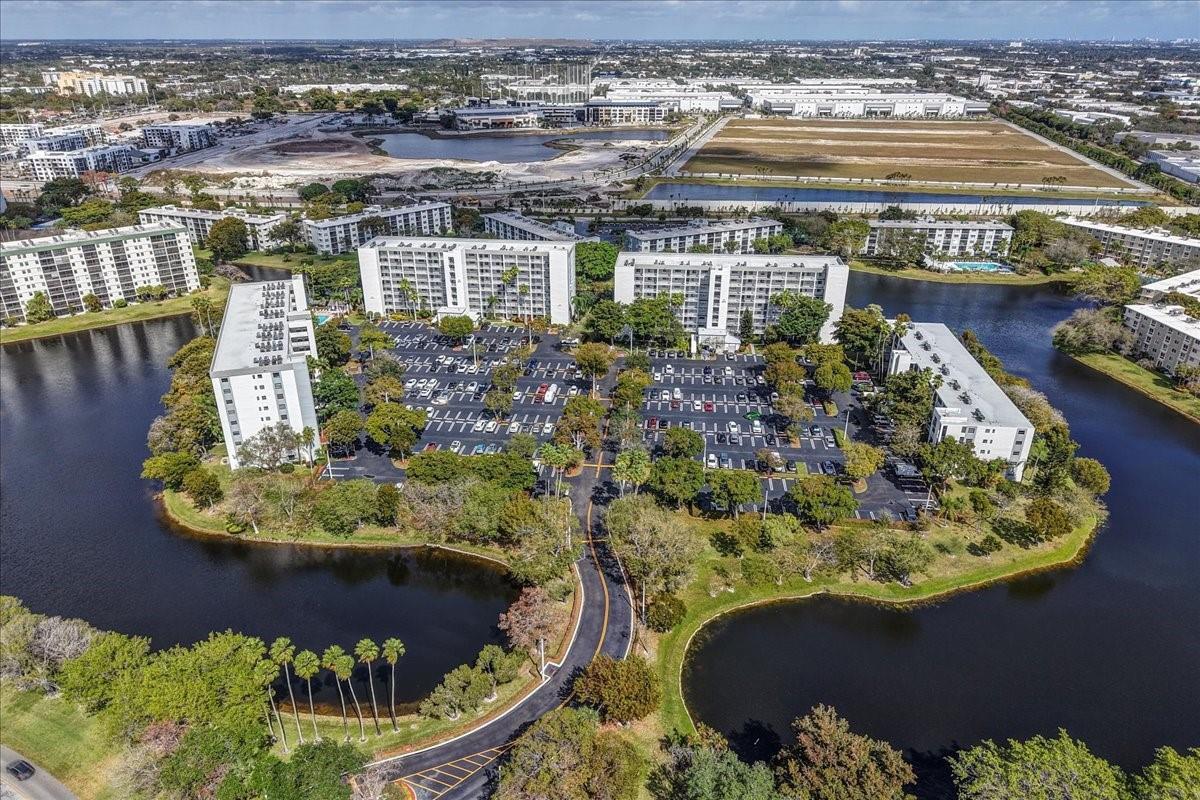 An aerial view of a multi-building apartment complex surrounded by a lake and parking lots — 2217 Cypress Island Drive # 507, Pompano Beach FL 33069, POMPANO BEACH, FL