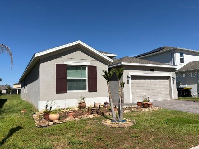 A single-story house with a beige stucco exterior, brown shutters, and a two-car garage — 2959 CAMDEN WAY, DAVENPORT, FL