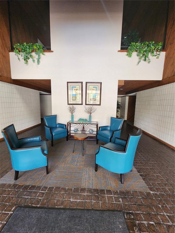 A lobby features four blue armchairs arranged around a small table on a patterned rug — 13612 S VILLAGE DRIVE UNIT 5307, TAMPA, FL